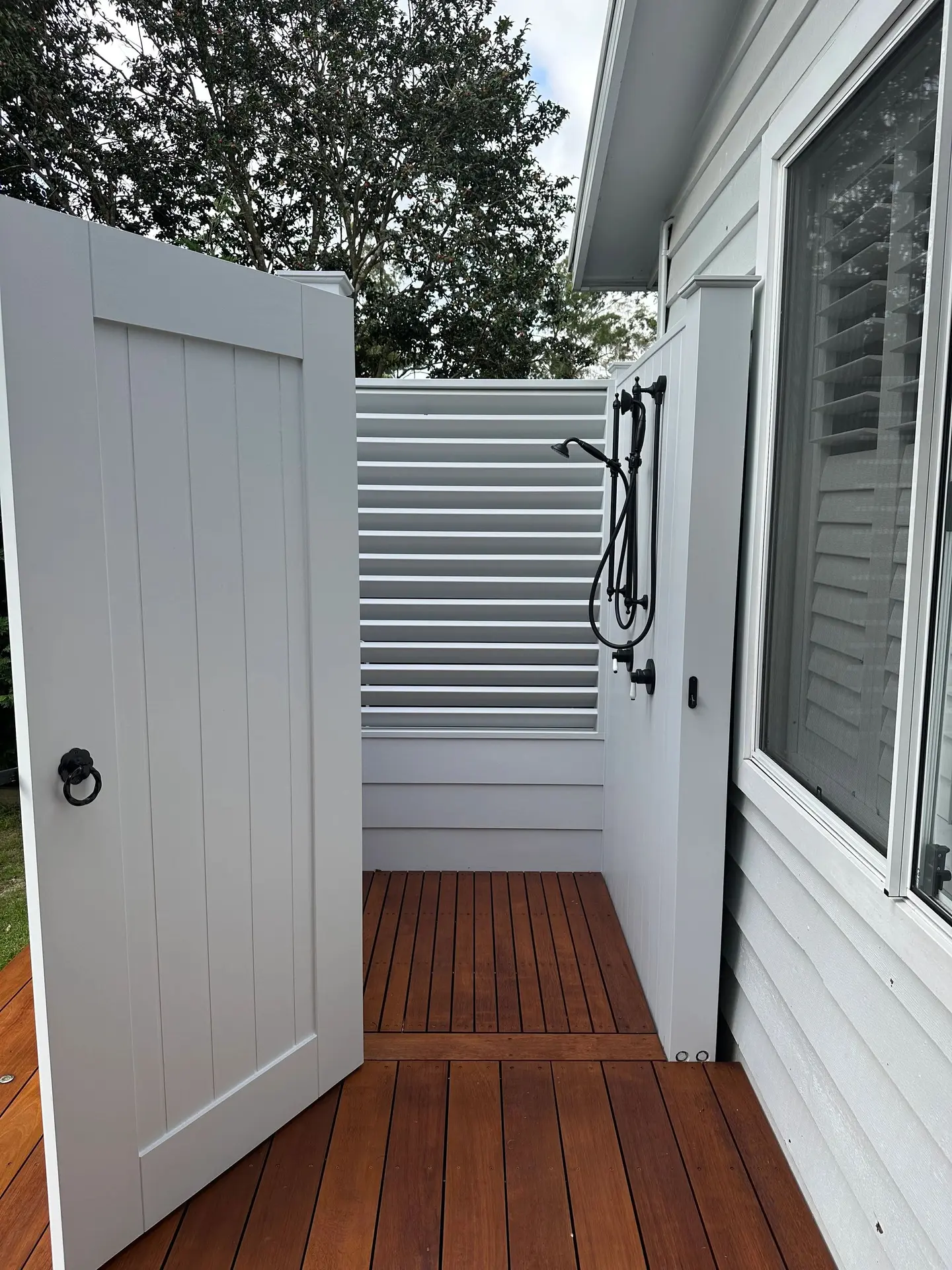 Outdoor shower integrated into a hardwood deck