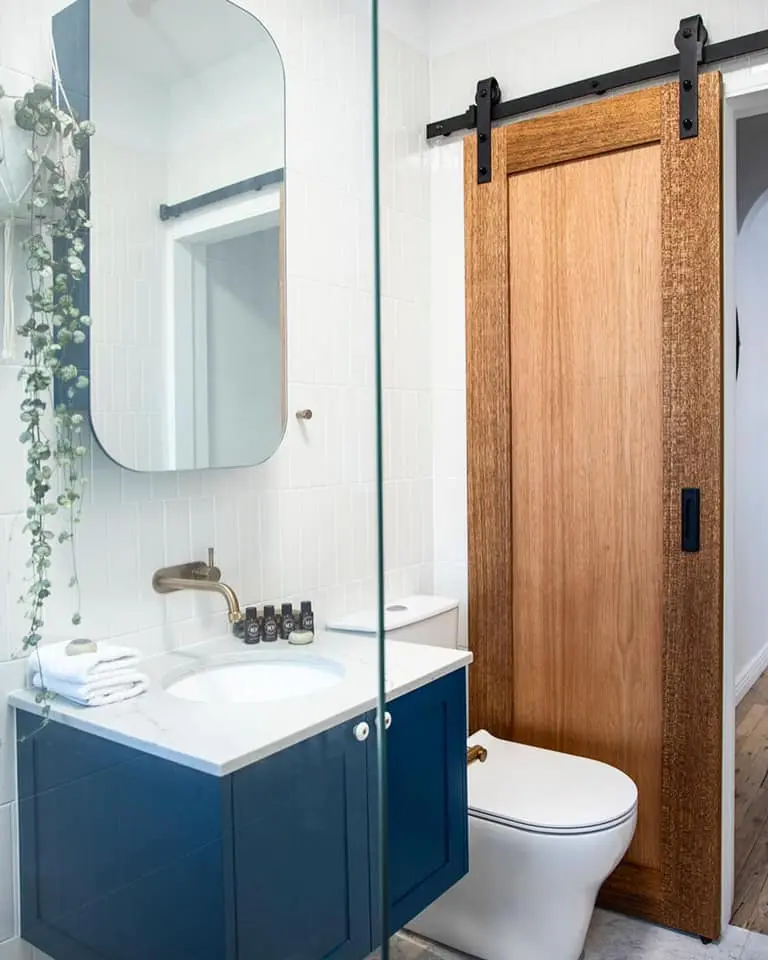Bathroom renovation with blue vanity and timber barn door in Bondi
