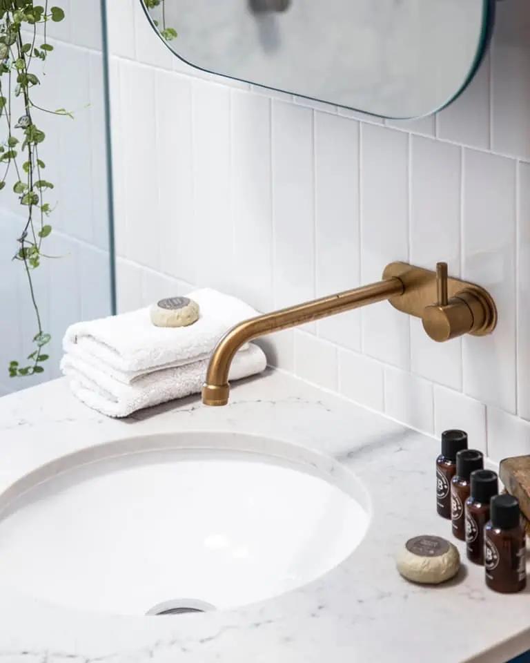 Close view of vanity, basin and brass tapware in the Bondi apartment bathroom