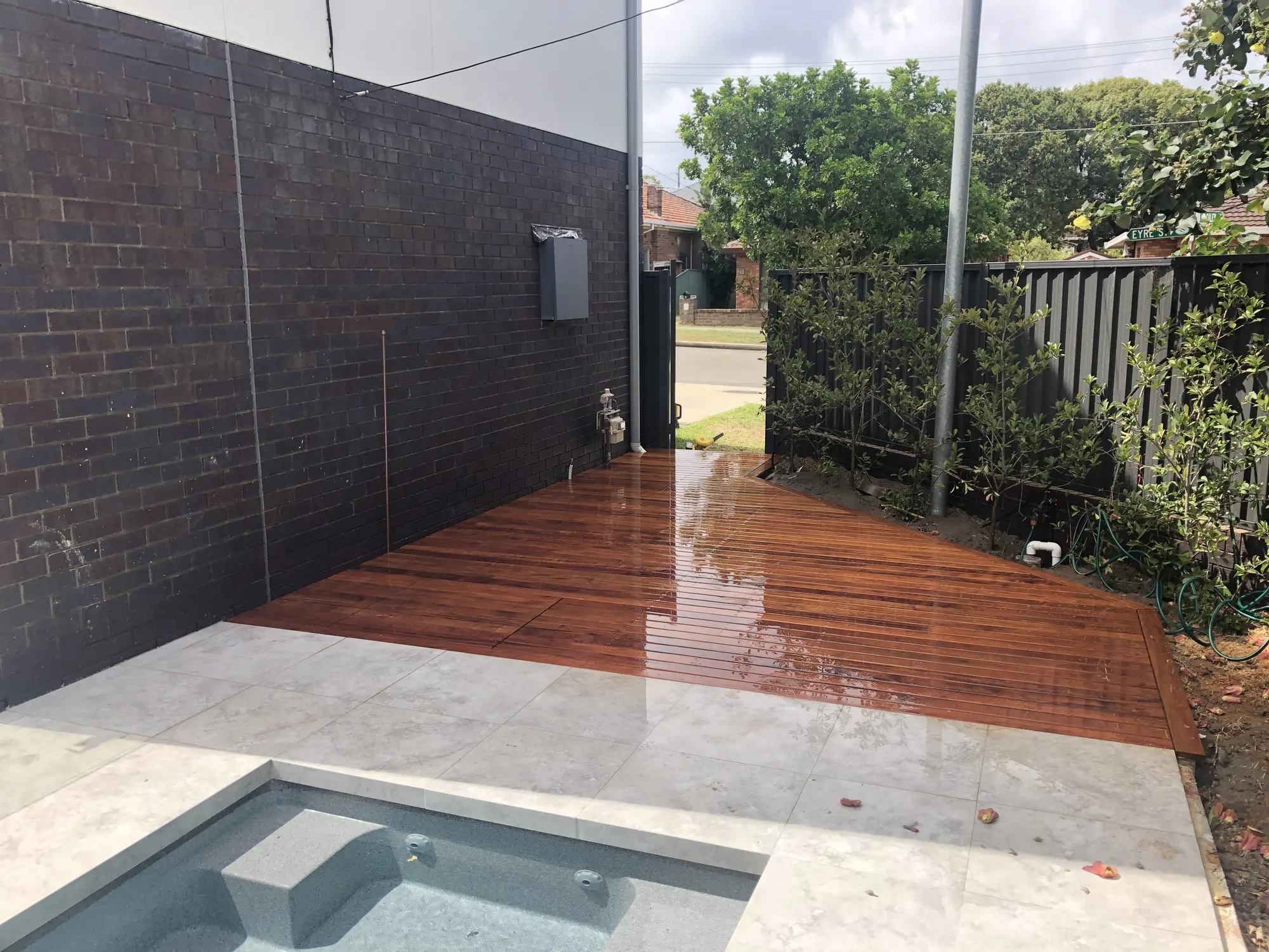 Merbau pool deck fitted around paving and pool edges in Chifley