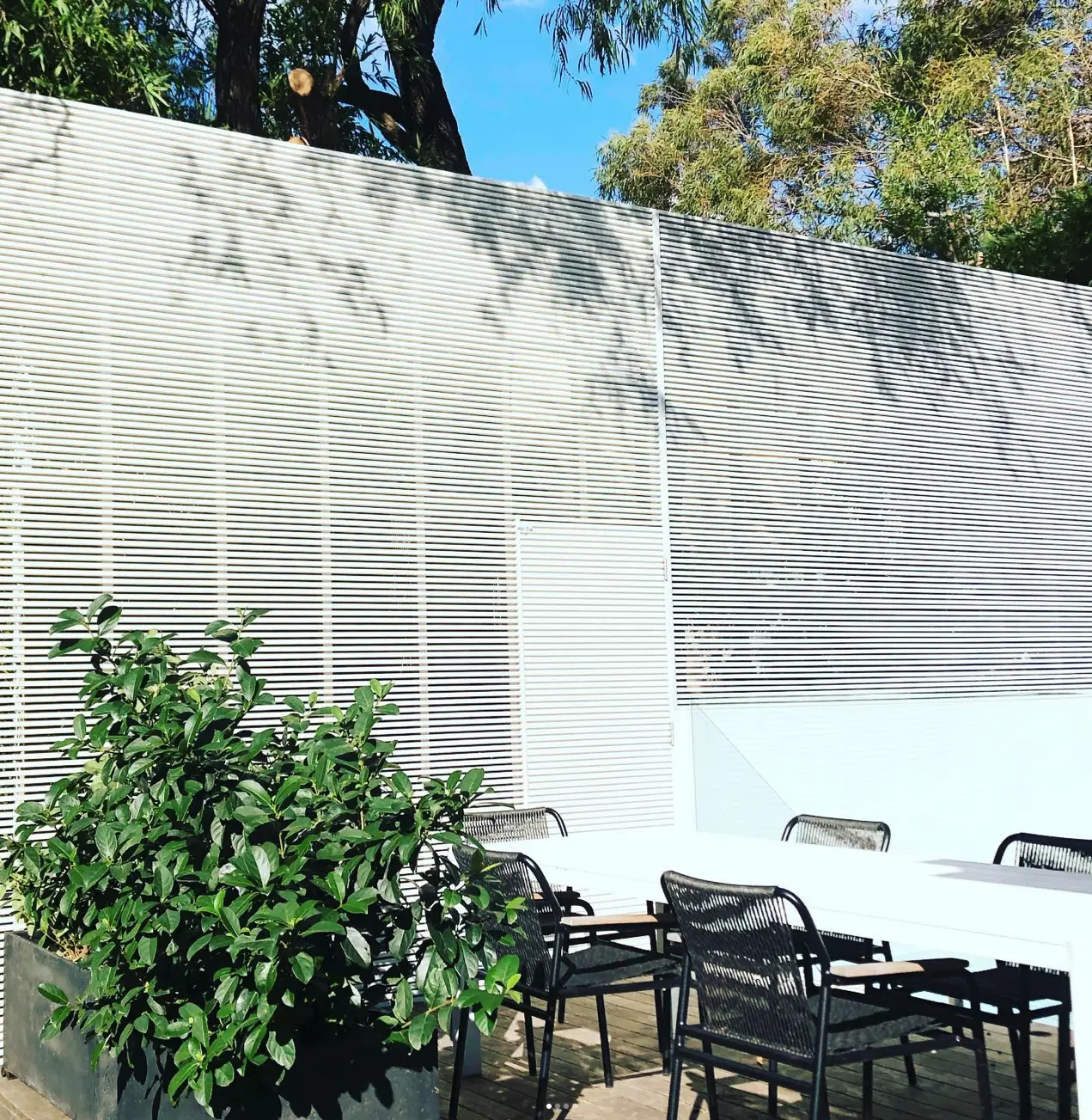 Painted privacy screen creating a sheltered outdoor dining area in Coogee