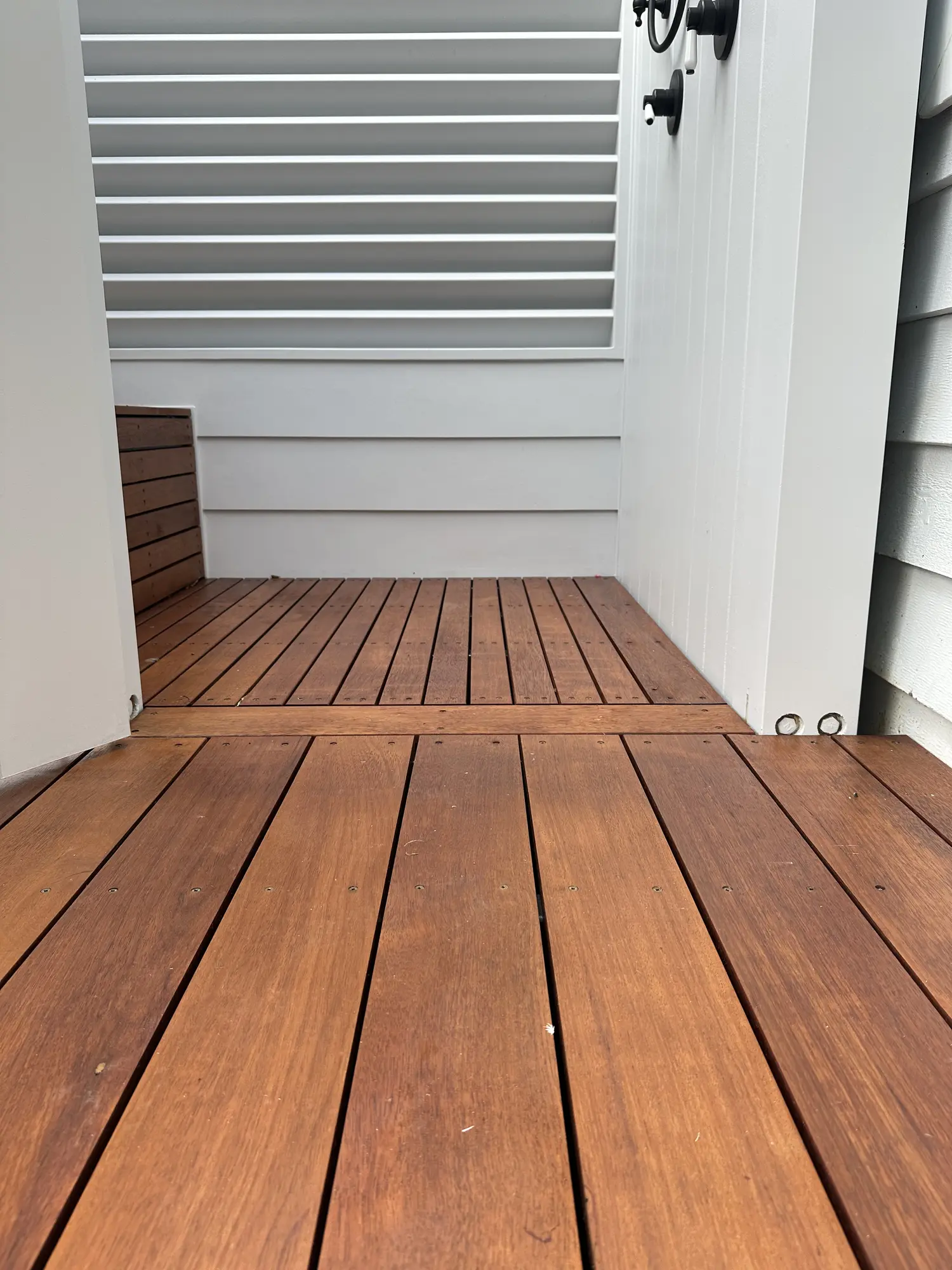 Close view of Merbau wet-area decking and custom shower carpentry in Erina Heights