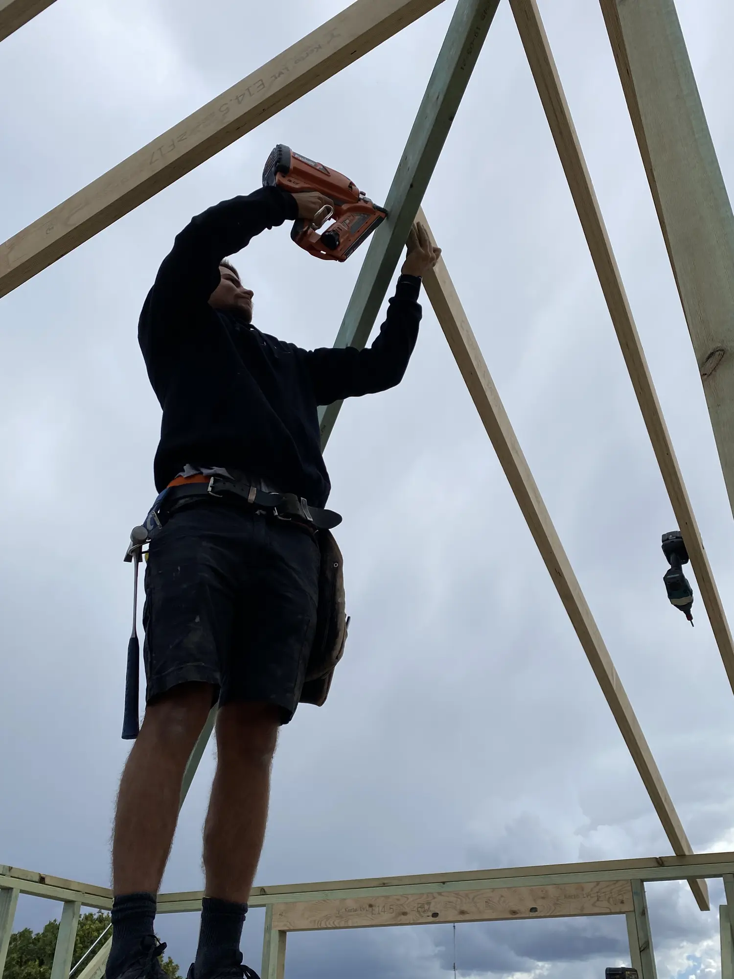 Carpenter fixing a precise roof-framing junction on a Maroubra renovation
