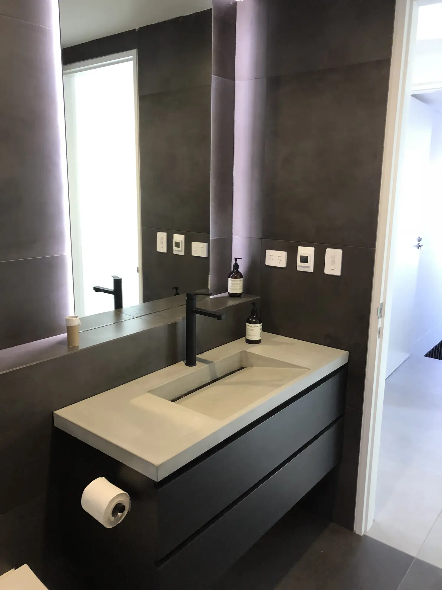Dark vanity and stone bathroom detailing in a Kensington residence