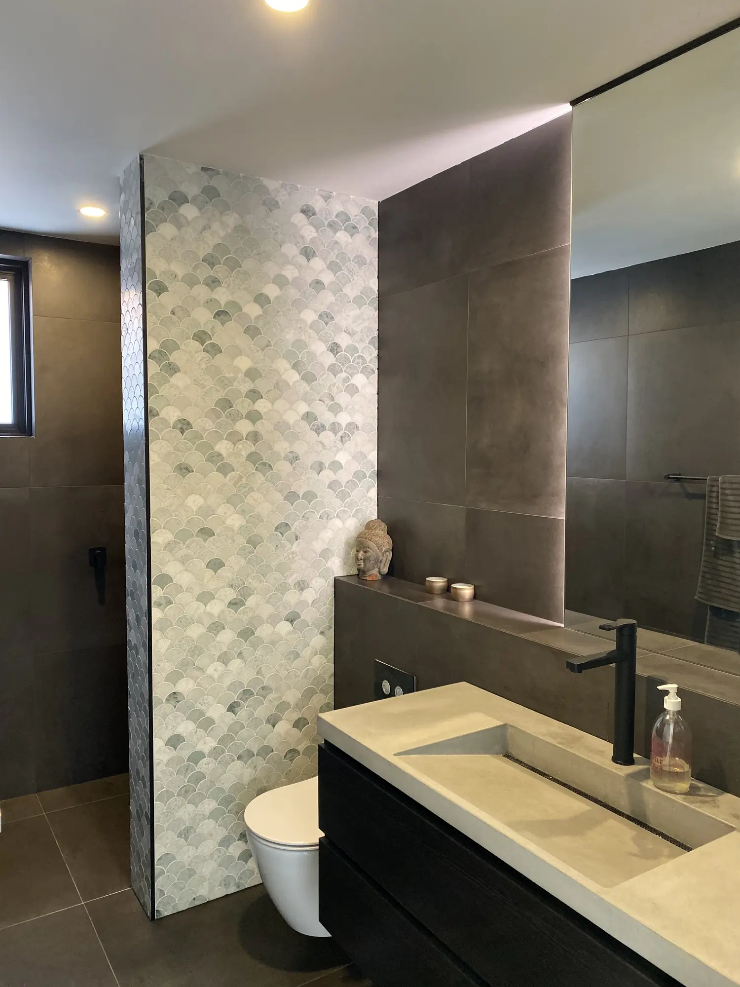 Detailed stone and dark-joinery bathroom in Kensington