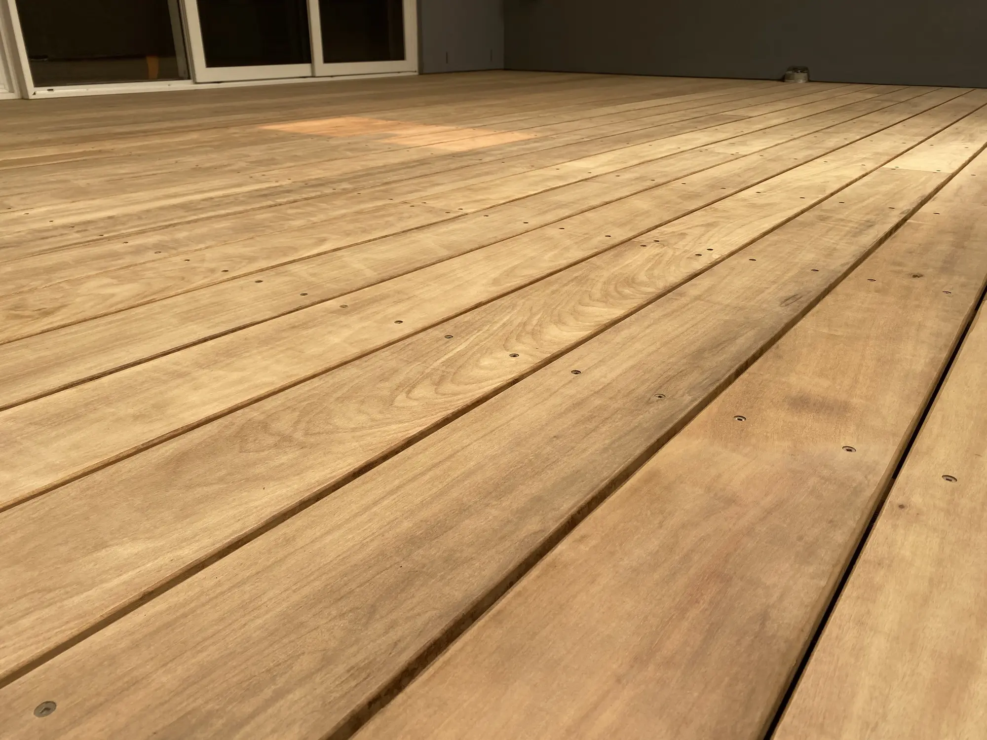 Close view of hardwood decking board alignment during a Maroubra renovation