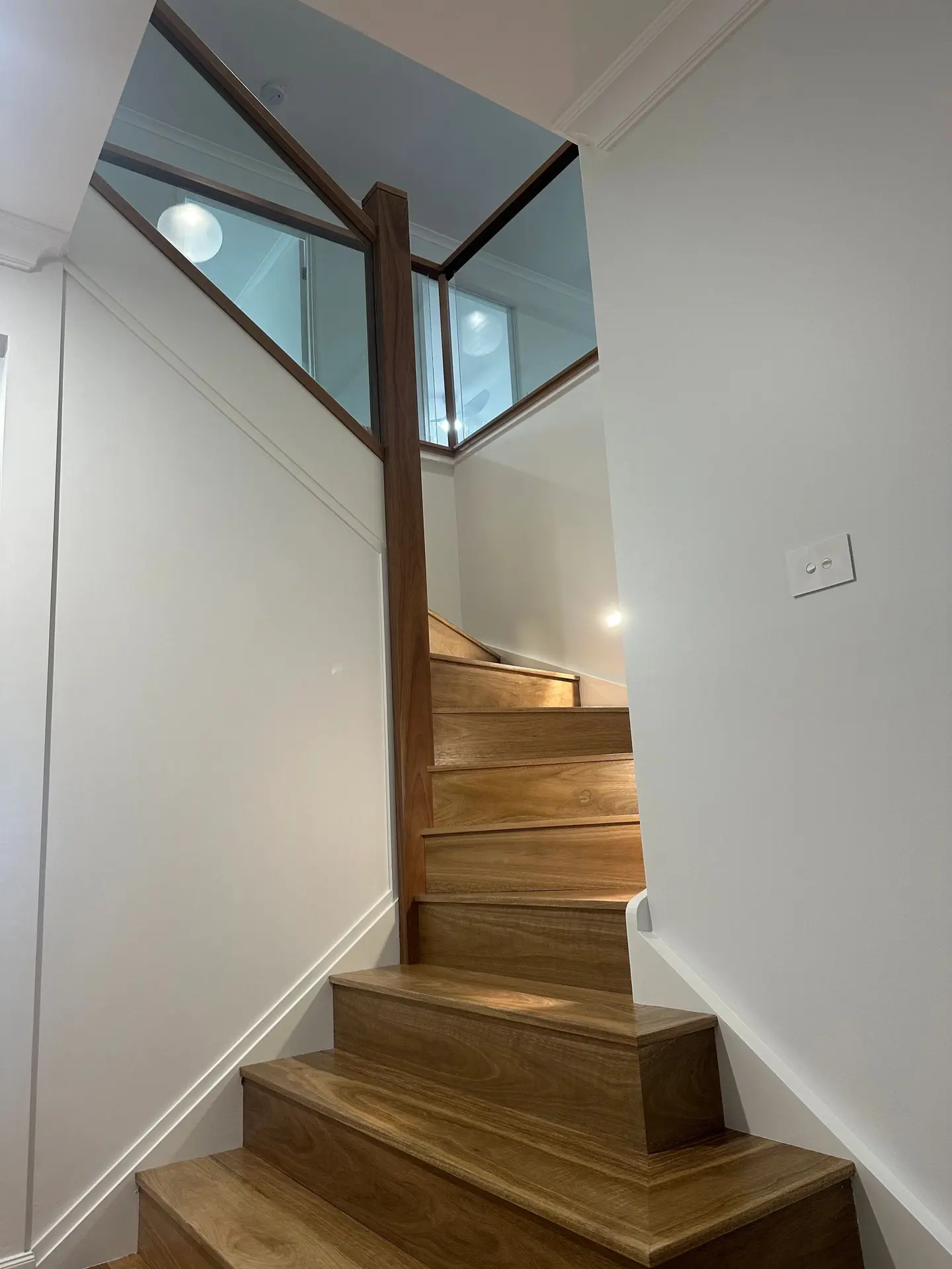 Hardwood stair and glass balustrade viewed from below